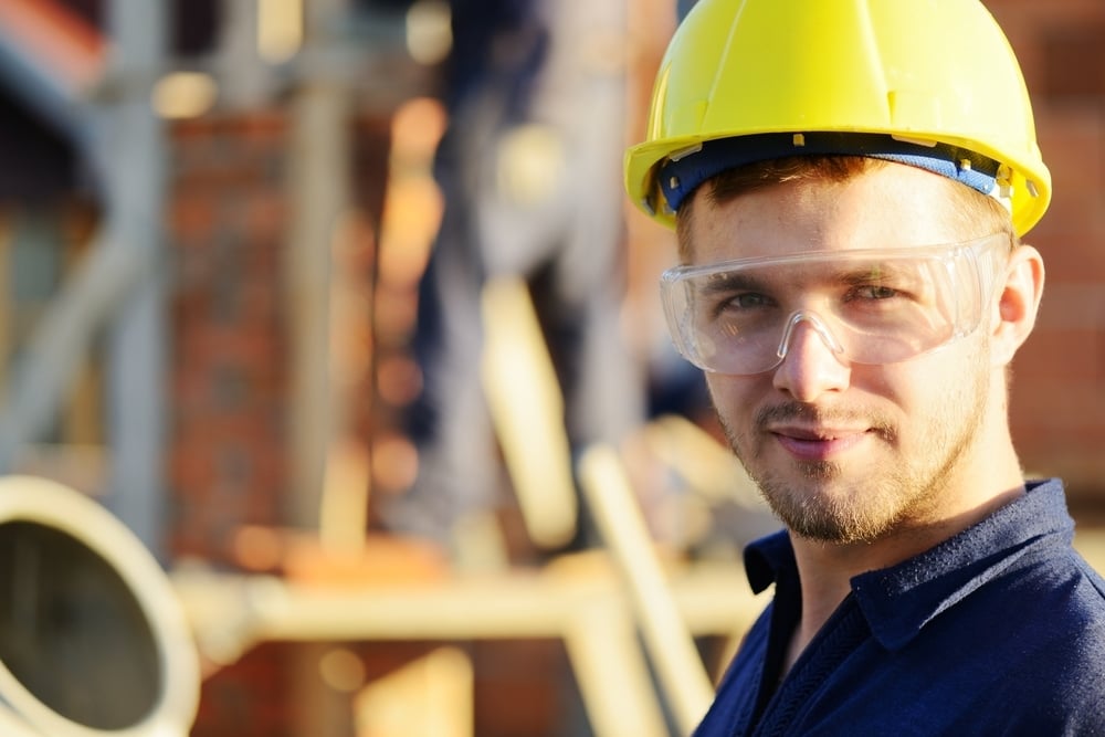 Male construction worker smiling at a building site Male construction worker smiling at a building site