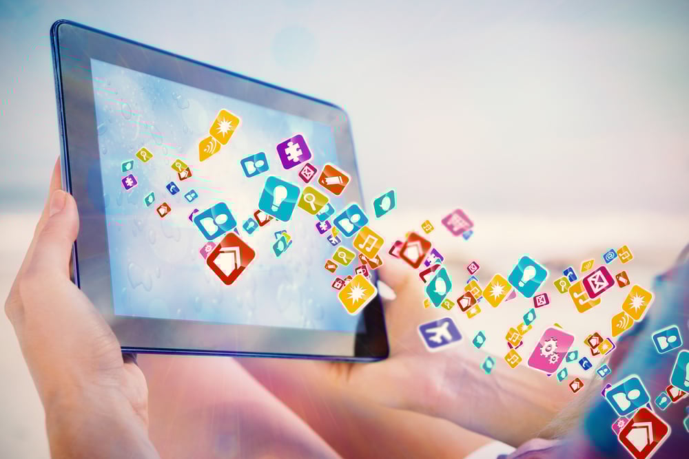 Woman sitting on beach in deck chair using tablet pc showing colourful computer applications Woman sitting on beach in deck chair using tablet pc showing colourful computer applications