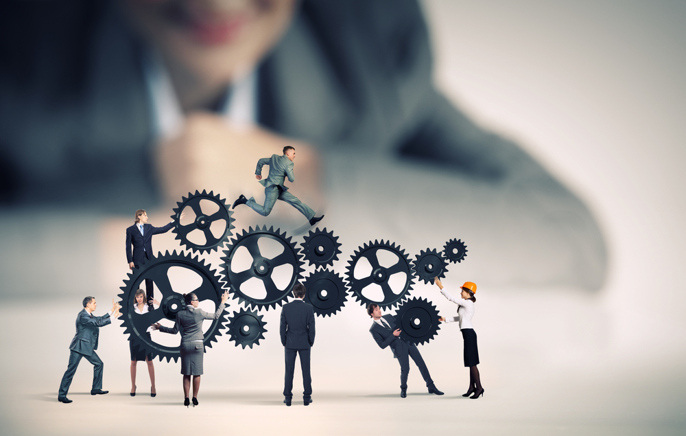 Businesswoman looking at team of businesspeople in miniature Businesswoman looking at team of businesspeople in miniature